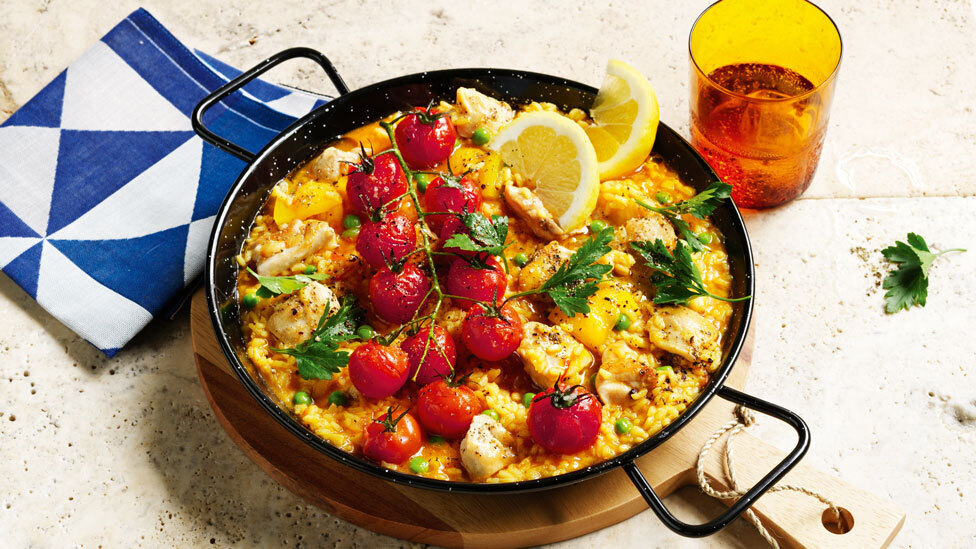 Chicken Paella in a pan, next to a tea towel